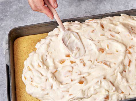 Schmand-Creme wird auf den Kuchen gestrichen