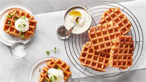 Schmand-Waffeln frisch gebacken auf Gitter, daneben Becher und Zutaten