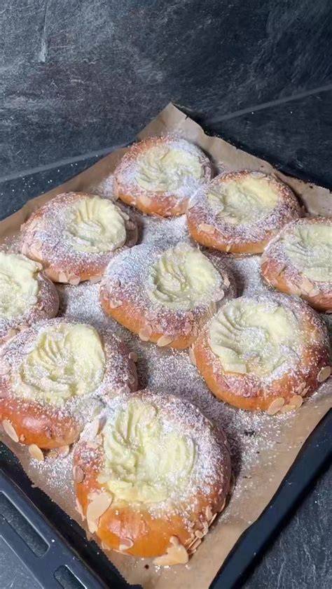 Schneeball Gebäck mit Puderzucker und Vanillepudding-Füllung auf rustikalem Brett