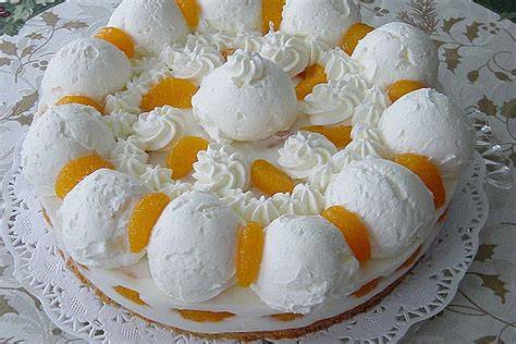 Schneeball-Torte mit Mandarinen: angeschnittene Torte und dekorative Schneekugeln