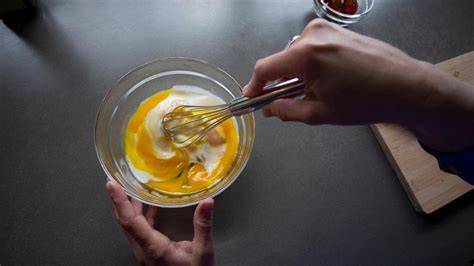 Schneebesen und Eiscreme im Glas als Darstellung zum Rühren