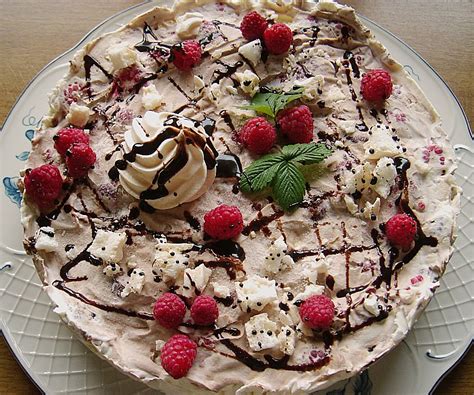 Schnitt einer Erdbeer-Parfait Eistorte mit Baiserboden und Schokoladendekoration