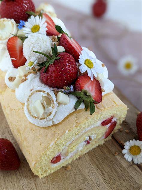 Schnitten der Erdbeer Biskuitrolle mit Sommerdeko am Kuchenbuffet