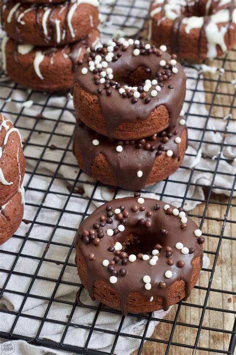Schoko Donuts auf dem Kuchengitter, einige verziert, einige pur