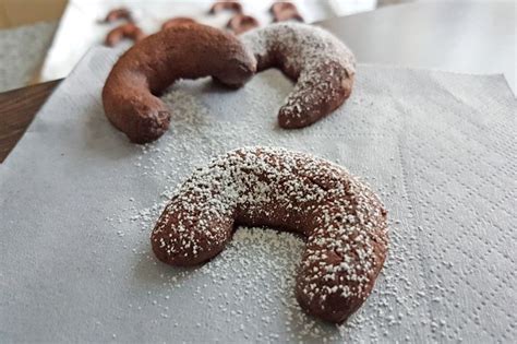 Schoko Vanille Kipferl auf Backblech mit Schokoladentauchung und Pistazien