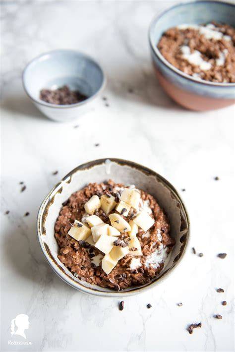 Schoko-Bananen-Porridge in Schüssel mit Banane und Kakaonibs