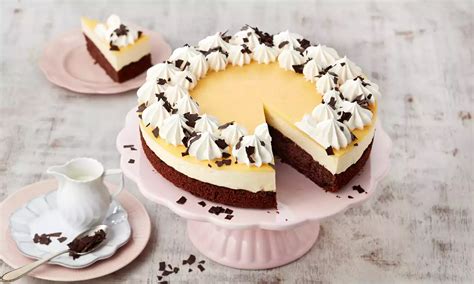 Schoko-Birnen-Kuchen angeschnitten auf Tortenplatte, angerichtet mit Sahnetupfen