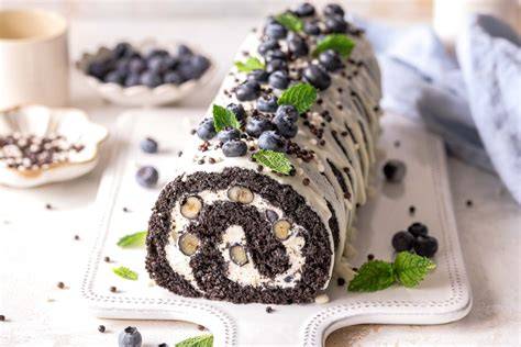 Schoko-Biskuitrolle mit Heidelbeeren, Anschnitt und Zutaten