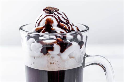 Schoko-Frappuccino im hohen Glas mit Sahne, Schokosauce und Chips
