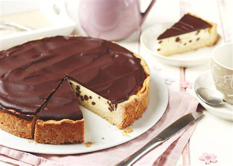 Schoko-Käsekuchen mit Schokosoße, Karamell und frischen Beeren als Dekoration