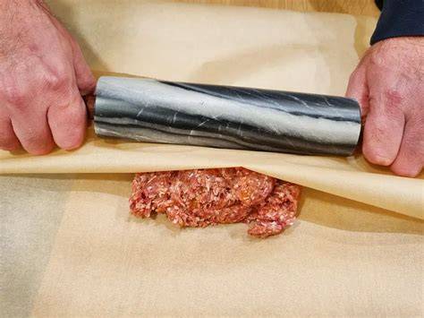 Schoko-Mandelsplitter auf Backpapier angerichtet, Detailaufnahme gerösteter Mandelstifte