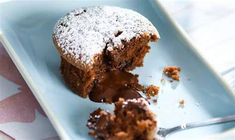 Schoko-Nougat-Muffins auf einem Teller, Schnitt zeigt flüssigen Kern