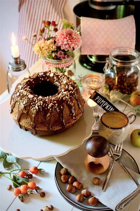 Schoko-Nuss-Gugelhupf auf Kuchenplatte mit Haselnüssen und Schokostücken
