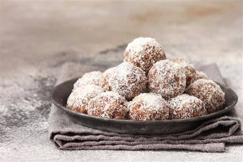 Schokobällchen angerichtet mit Kokosraspeln und Zimtstangen