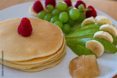 Schokocreme, angerichtet mit Pancakes, Obst und Brot auf einem Brunch-Tisch