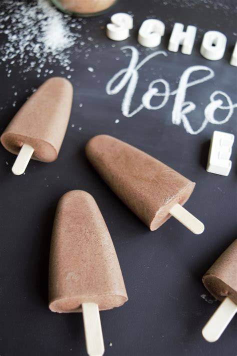 Schokoeis am Stiel - Zutaten und fertige Eislutscher auf einem Holzbrett