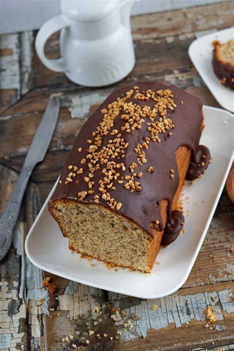 Schokoguss auf Nusskuchen streichen mit gerösteten Nüssen