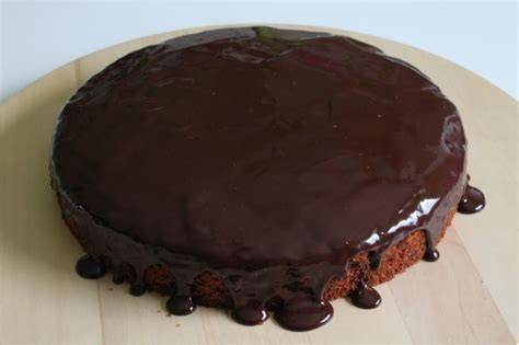 Schokoguss wird auf den Kuchen gestrichen
