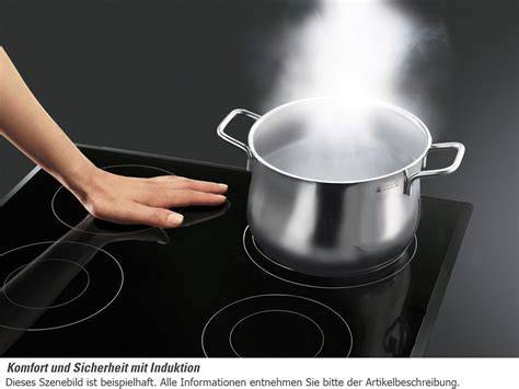 Schokolade in kleinen Stücken im Topf auf dem Induktionsherd
