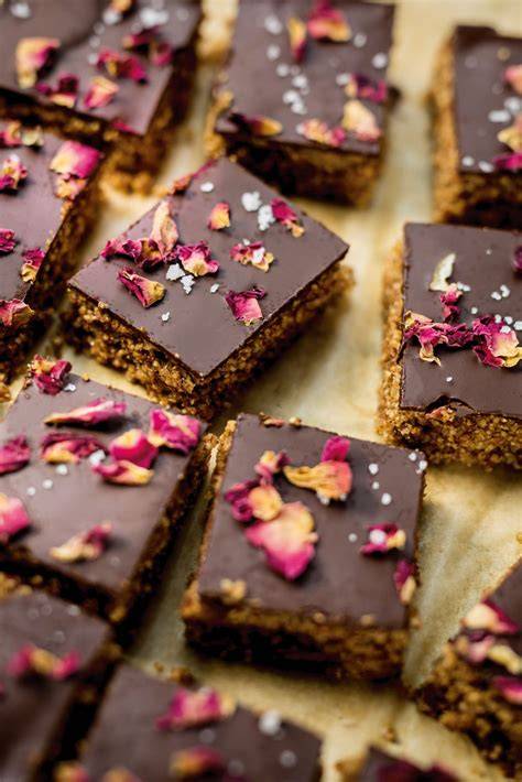 Schokolade mit Rosenblüten auf Marmorplatte, Rosenblätter daneben