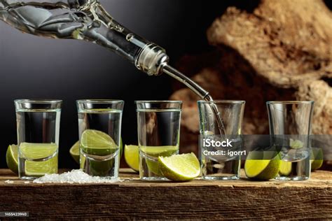 Schokolade und Spirituosen flach gelegt auf Holzbrett, daneben Gläser mit verschiedenen Alkoholika