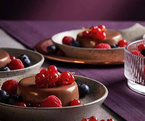 Schokoladen Panna Cotta in Dessertgläsern garniert mit frischen Beeren