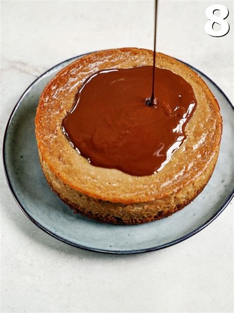 Schokoladen-Ganache wird über den gekühlten Käsekuchen gegossen