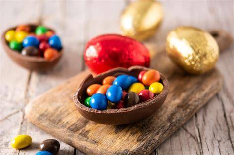 Schokoladeneier und Zutaten auf Holztisch