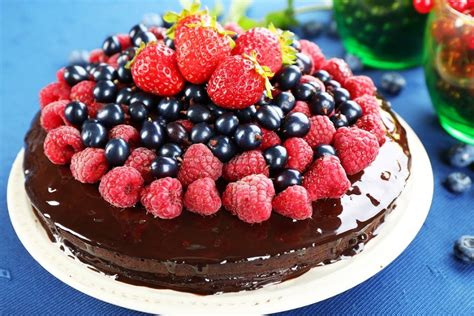 Schokoladenkuchen angerichtet mit Beeren, Eis und Karamellsoße