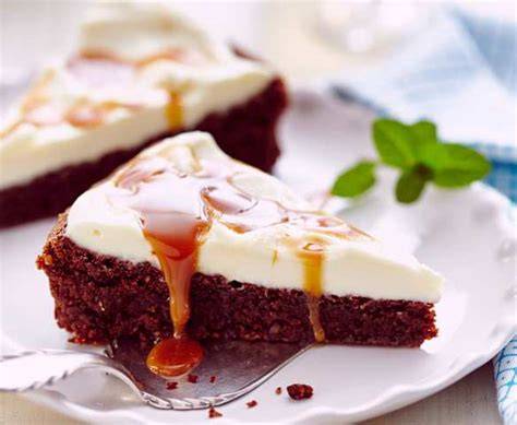 Schokoladenkuchen mit Karamell und Frischkäse-Topping, angeschnittenes Stück
