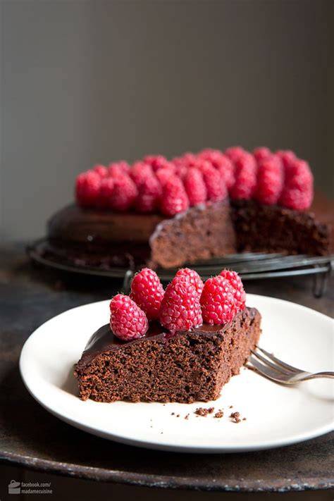 Schokoladenkuchen verziert mit frischen Himbeeren und essbaren Blüten