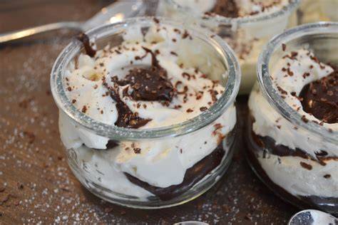 Schokoladensauce im Glas neben Dessertgläsern