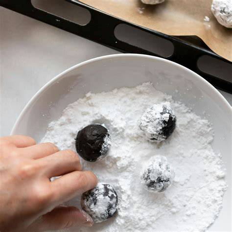 Schokoladenteig-Kugeln im Puderzucker gewälzt vor dem Backen