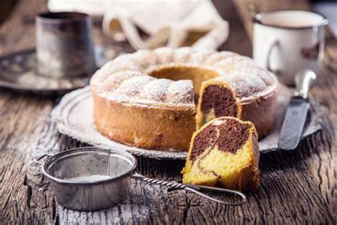Schokoladiger Marmorkuchen mit Marmormuster neben Kakaopulver