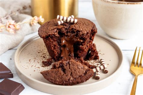 Schokomuffins mit flüssigem Kern auf Teller, Schnittbild mit auslaufender Schokolade