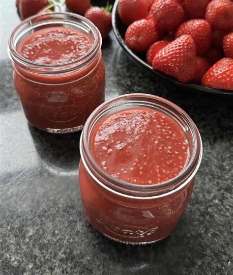 Schraubgläser mit selbstgemachter Marmelade, Mixtopf im Hintergrund