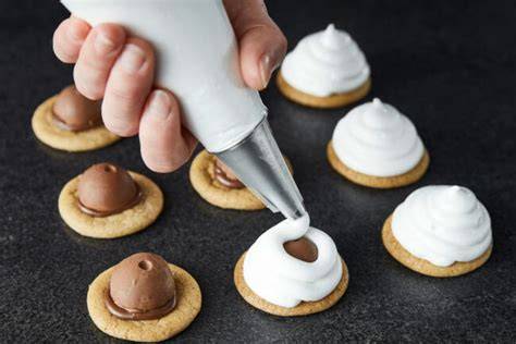 Schritt: Schaumküsse werden auf Waffelböden gespritzt