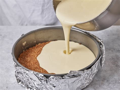 Schritt 2: Cremige Frischkäse-Sahne-Füllung auf den Keksboden streichen