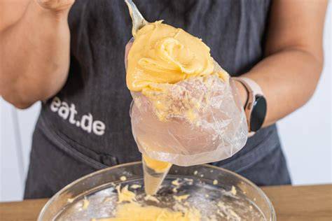 Schritt für Schritt: Mit Spritzbeutel Cremetupfen auf Zahlenkuchen geben (Fotostrecke)