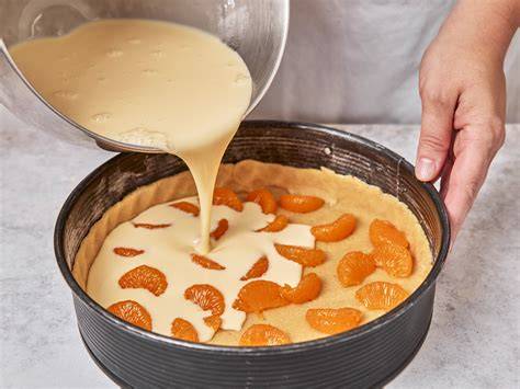 Schritt für Schritt: Schmandcreme und Mandarinen auf Teigboden verteilen