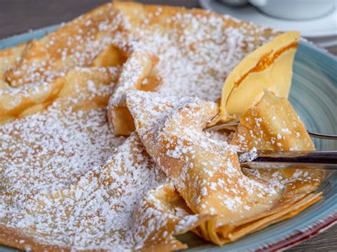 Schritt-für-Schritt-Infografik: Crêpe falten und mit Puderzucker bestäuben