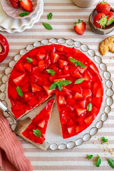 Schritt-für-Schritt-Infografik: Keksboden, Creme, Erdbeeren, Tortenguss