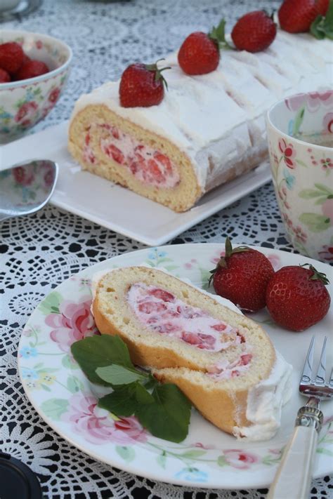 Schritt-für-Schritt-Rolle: Biskuitplatte mit Creme und Erdbeeren darauf, bereit zum Einrollen
