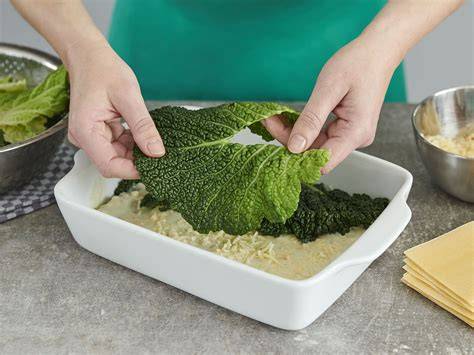Schrittfolge: Blanchierte Wirsingblätter, Hack-Schicht, Kartoffelscheiben, Wirsing, Abdecken