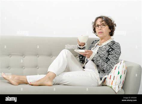 Schwangere Frau trinkt Tee auf dem Sofa