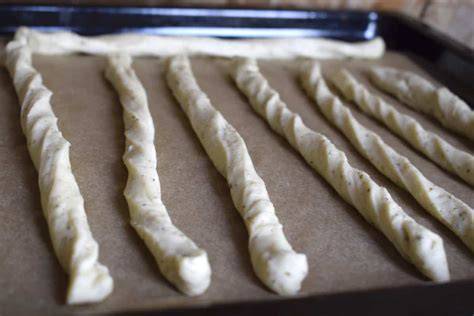 Selbstgemachte Grissini vor dem Backen auf dem Blech