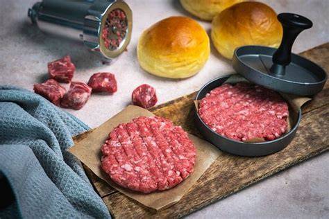 Selbstgemachte Patties auf dem Brett, bereit fürs Braten