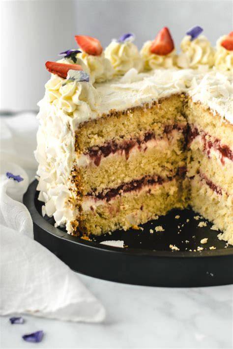 Selbstgemachte Vanilletorte mit frischen essbaren Blüten dekoriert