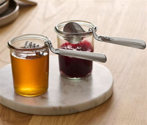 Senfglas und Honiglöffel auf Holztisch