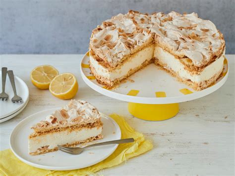 Servierszene: Limoncello-Torte auf Tortenplatte mit Zitronen und Limoncello-Glas